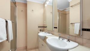 a bathroom with two sinks and a large mirror at Lawlers 29 in Mount Hotham