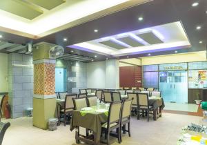 Hotel Golden Inn Chattagram Ltd في شيتاغونغ: مطعم فيه طاولات وكراسي في الغرفة
