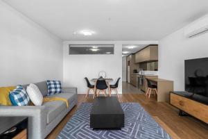ein Wohnzimmer mit einem Sofa und einem Tisch in der Unterkunft Perfect Urban Retreat! in Melbourne