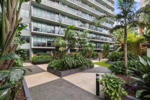un edificio de apartamentos con un patio con árboles y plantas en Perfect Urban Retreat!, en Melbourne