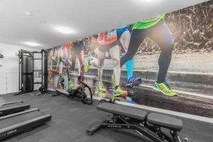 a gym with a large painting of a race on the wall at Perfect Urban Retreat! in Melbourne