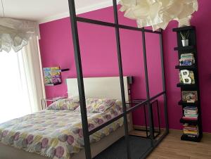 a bedroom with a pink wall and a bed at Gallery 123 Luxury Room in Agrigento