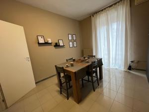 a dining room with a table and chairs and a window at Esme House in Foggia