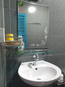 een badkamer met een witte wastafel en een spiegel bij Masawi Home in Can Tho