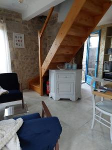 a living room with a staircase and a table and chairs at La petite maison bleue in Mouret