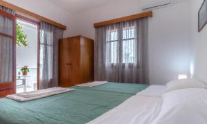 a bedroom with two beds and a window at Antigoni Apartments 'Lavender Room' in Milatos