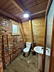 a wooden bathroom with a toilet and a sink at Life on the farm in Nepravishtë
