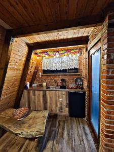 a kitchen in a log cabin with a table and a window at Life on the farm in Nepravishtë
