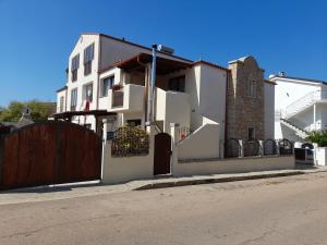 a white house with a gate and a fence at Bella e Nuova casa vacanze Sardegna in Lotzorai