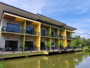 un edificio junto a una masa de agua en Saithong Resort, en Pak Meng