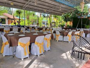 eine Gruppe von Tischen und Stühlen mit gelben Bogen in der Unterkunft Saithong Resort in Pak Meng