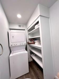 a small white refrigerator in a white kitchen at Rustic Retreat Cottage in Payson