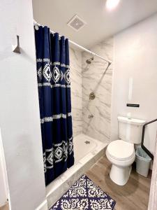 uma casa de banho com um WC e uma cortina de chuveiro azul em Rustic Retreat Cottage em Payson