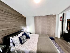 Rustic Retreat Cottage في بايسون: غرفة نوم بسرير كبير وبجدار خشبي