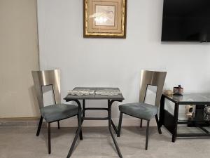 a table and two chairs and a table and a television at Rustic Retreat Cottage in Payson