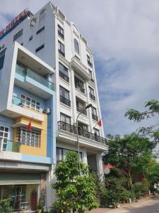 un edificio blanco alto con banderas delante en SUN HOTEL & APARTMENT en Bắc Ninh