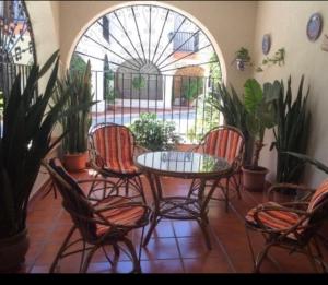 eine Terrasse mit einem Tisch, Stühlen und Pflanzen in der Unterkunft Chalet en la playa in Salobreña