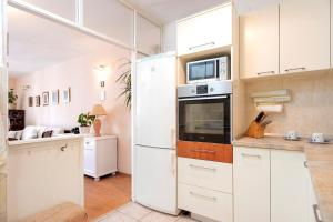 a kitchen with white cabinets and a white refrigerator at Mirjana Apartment in Hvar