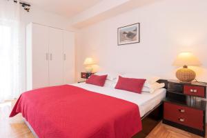 a bedroom with a large bed with a red blanket at Mirjana Apartment in Hvar