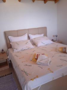 a bed with white sheets and flowers on it at Holiday Home Zule in Žrnovo