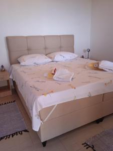 a bedroom with a large bed with white sheets and pillows at Holiday Home Zule in Žrnovo