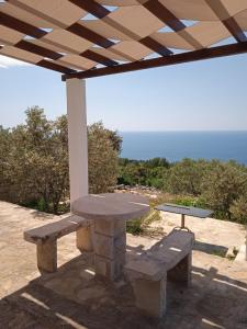 a picnic table and bench under a pergola at Holiday Home Zule in Žrnovo