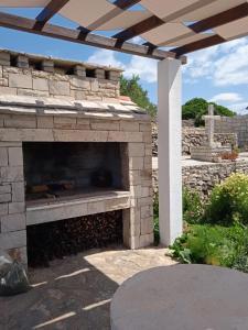 a stone fireplace in a yard with a patio at Holiday Home Zule in Žrnovo