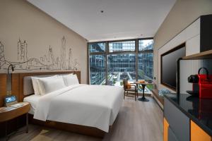 a bedroom with a large white bed and a large window at UrCove by HYATT Futian CBD in Shenzhen
