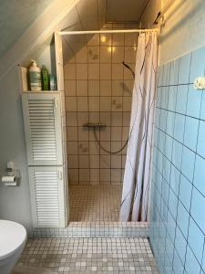 a bathroom with a shower with a shower curtain at JM B&B in Sakskøbing