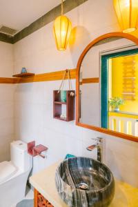 Boutique Villa in Hoi An Oldtown في هوي ان: حمام مع حوض ومرآة