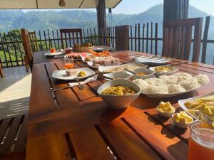 a wooden table with many dishes of food on it at Brisk Ella Retreat in Ella