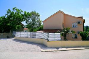 a house with a white fence in front of it at Holiday Home Mumy in Gostinjac