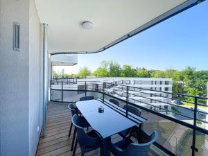 einen Balkon mit einem Tisch und Stühlen auf einem Gebäude in der Unterkunft E&K living - 6 pers - design apartment - fair - congress - parking in Augsburg