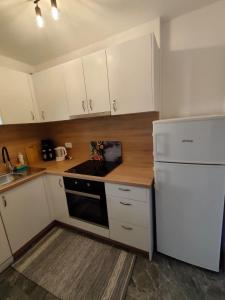a kitchen with white cabinets and a white refrigerator at Apartments Ankica Blue in Peroj