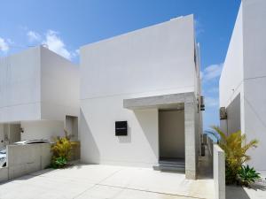 a white house with a large entrance at Onna Resort 海まで徒歩0秒 最大12名宿泊可 オーシャンビュー貸切ヴィラ in Nago