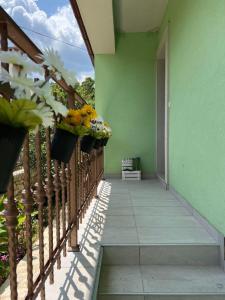 uma varanda de uma casa com flores em baldes em Holiday Home Lupita 2 em Vinjerac