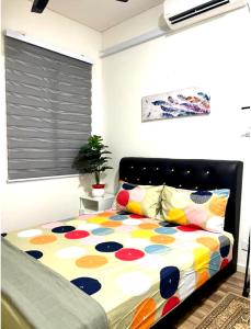 a bedroom with a bed with a colorful comforter at Homestay Ika KLIA @ Enstek in Kampong Chinchang