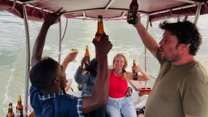 a group of people on a boat drinking beer at Lake Bunyonyi Rock Resort in Kabale