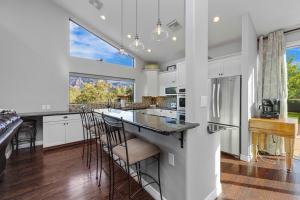 a kitchen with white cabinets and a island with bar stools at Sedona Uptown Gem! Wow! Views!! Close to trails, walk to Uptown Sedona, restaurants and shopping in Sedona