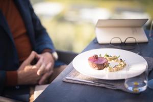 a person sitting at a table with a plate of food at Hotel Winkler Sport & Spa Resort in San Lorenzo di Sebato