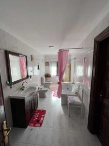 a bathroom with two sinks and a tub and two toilets at Casa Rural La Pereda in Noriega