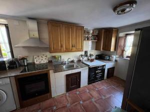 a kitchen with a sink and a stove top oven at Casa Rural La Pereda in Noriega