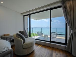 a bedroom with a view of the ocean from a balcony at Onna Resort 海まで徒歩0秒 最大12名宿泊可 オーシャンビュー貸切ヴィラ in Nago