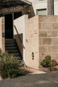 a brick house with a staircase leading to a door at Hearns Beachside Villa 9 in Port Fairy