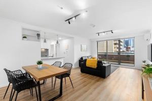 2-Bedroom Apartment in Paris End of Melbourne CBD في ملبورن: غرفة معيشة مع طاولة وأريكة