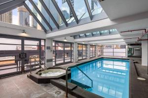 2-Bedroom Apartment in Paris End of Melbourne CBD في ملبورن: مسبح كبير في مبنى به نوافذ