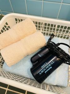 a laundry basket with a blow dryer and a towel at Osaka KAYA Traditional Tatami house 2-6 ppl near station and park direct to KIX airport in Osaka