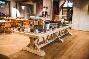 una larga mesa de madera con comida encima en Gekko House Frankfurt, a Tribute Portfolio Hotel en Frankfurt