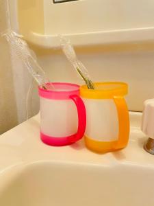 two colorful cups sitting on top of a sink at Osaka KAYA Traditional Tatami house 2-6 ppl near station and park direct to KIX airport in Osaka