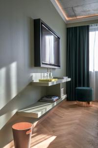 a living room with a television and a chair at Gekko House Frankfurt, a Tribute Portfolio Hotel in Frankfurt